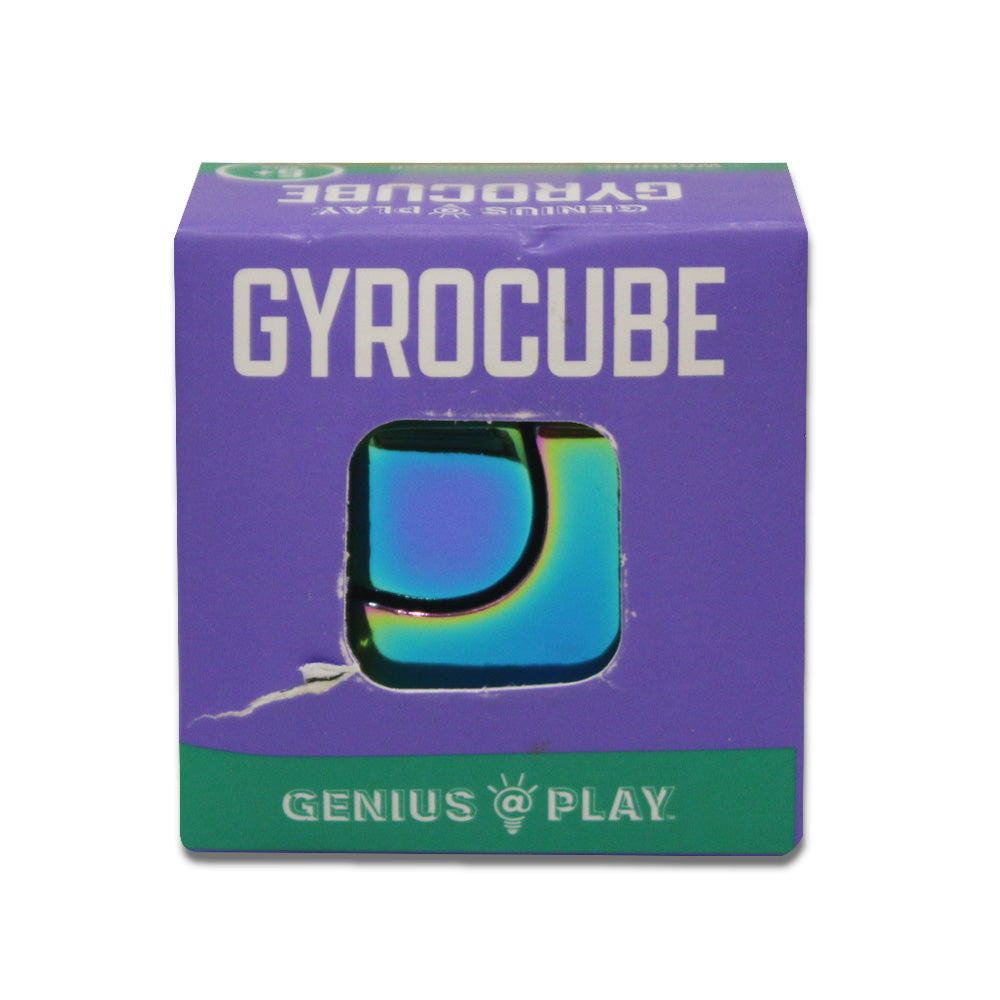 A small purple and green box labeled GAP Gyro Cube Fidget in bold white letters features a cut-out displaying a shiny, colorful curved toy inside, with GENIUS @ PLAY at the bottom—ideal for focus and relaxation.