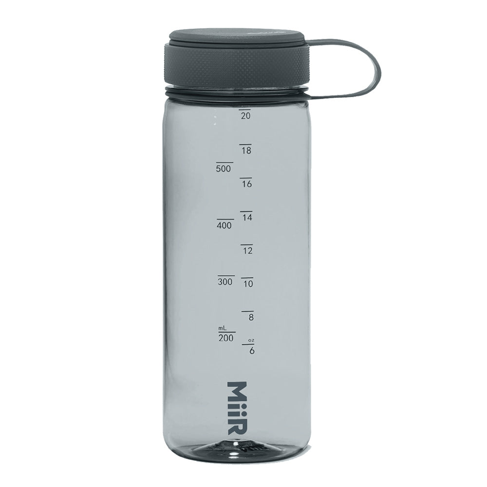 Stay hydrated in style with the Museum of Science Boston Ombre Cliff the Dino Water Bottle, a clear plastic design featuring a gray screw-on lid and a convenient carrying loop. Measurement markings in both milliliters and ounces are printed on the side, along with the MiiR brand name at the base. Made from recycled materials and inspired by the Museum of Science Boston, this eco-friendly water bottle is perfect for science enthusiasts.