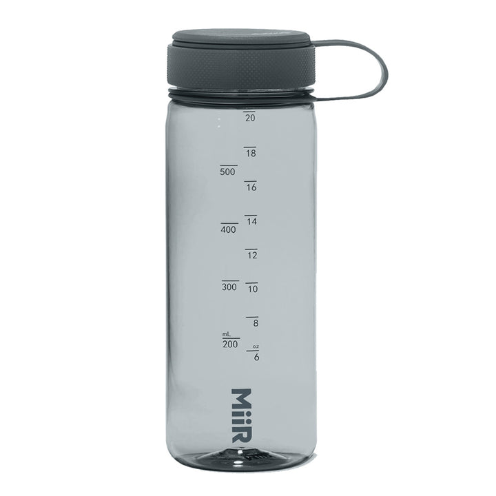 Stay hydrated in style with the Museum of Science Boston Ombre Cliff the Dino Water Bottle, a clear plastic design featuring a gray screw-on lid and a convenient carrying loop. Measurement markings in both milliliters and ounces are printed on the side, along with the MiiR brand name at the base. Made from recycled materials and inspired by the Museum of Science Boston, this eco-friendly water bottle is perfect for science enthusiasts.