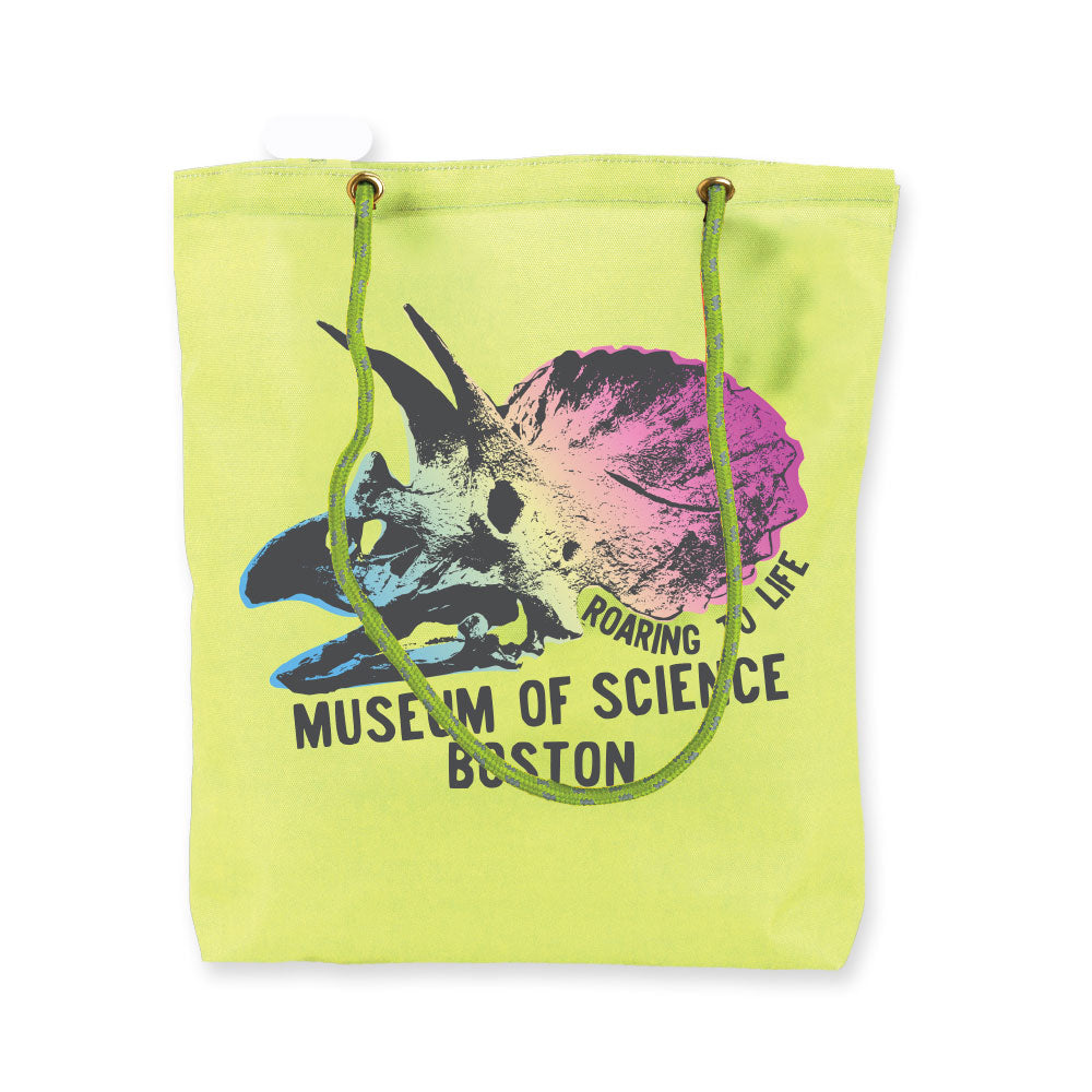 Introducing the Museum of Science Boston Cliff the Dino Rope Tote—a light green, eco-friendly tote bag showcasing a vibrant triceratops skull and shell graphic with the text “Roaring to Life Museum of Science Boston.” This exclusive features unique green and yellow rope handles, adding a playful flair to your Museum of Science Boston experience.