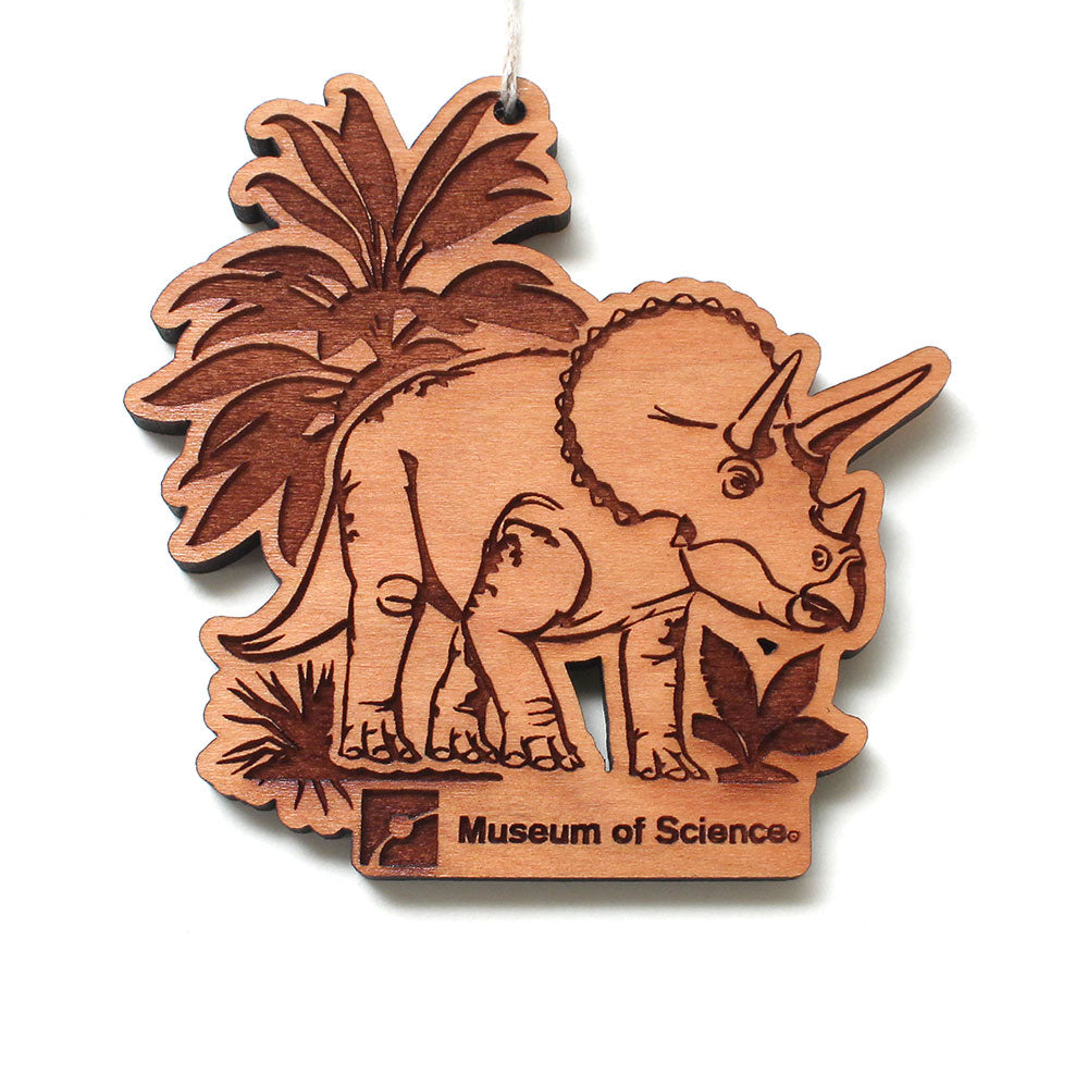 Museum of Science Boston Cliff the Dino Wood Ornament—featuring an engraved triceratops among plants with “Museum of Science Boston” inscribed at the bottom—makes a delightful dinosaur gift and a charming wood ornament for science enthusiasts.