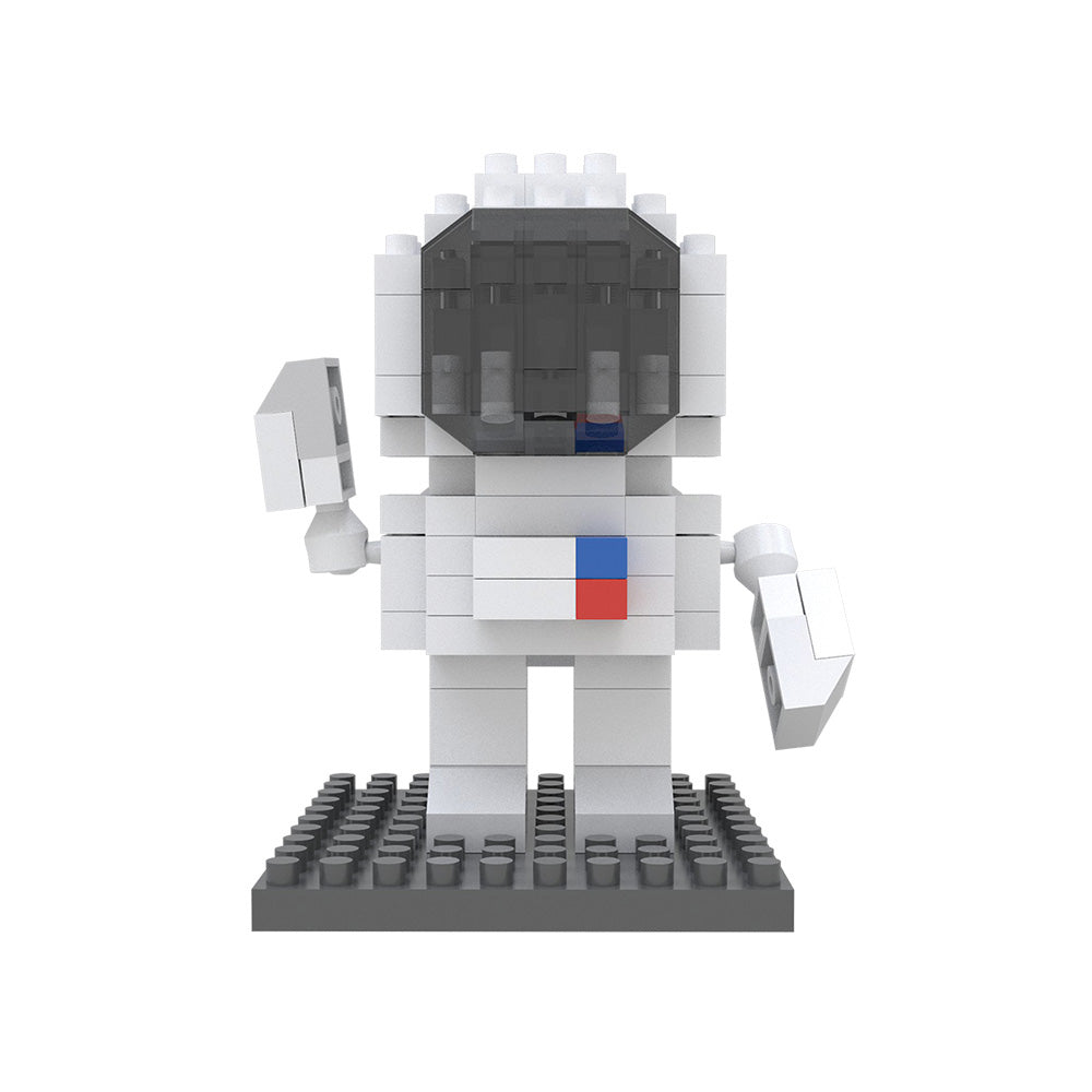 A small astronaut figure constructed from white Space Mystery Mini Blocks stands on a black base, featuring a dark helmet visor and red and blue square details on its chest—a collectible set designed to inspire creativity and problem-solving skills.
