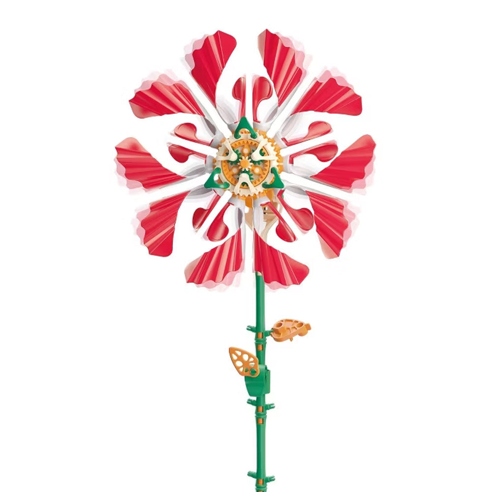 Introducing the Solar Flower Kit Ruby Ripple—a vibrant model flower featuring striking red and white petals, a green stem, and bright yellow gears. This motorized kinetic sculpture is perfect as an educational or mechanical toy.