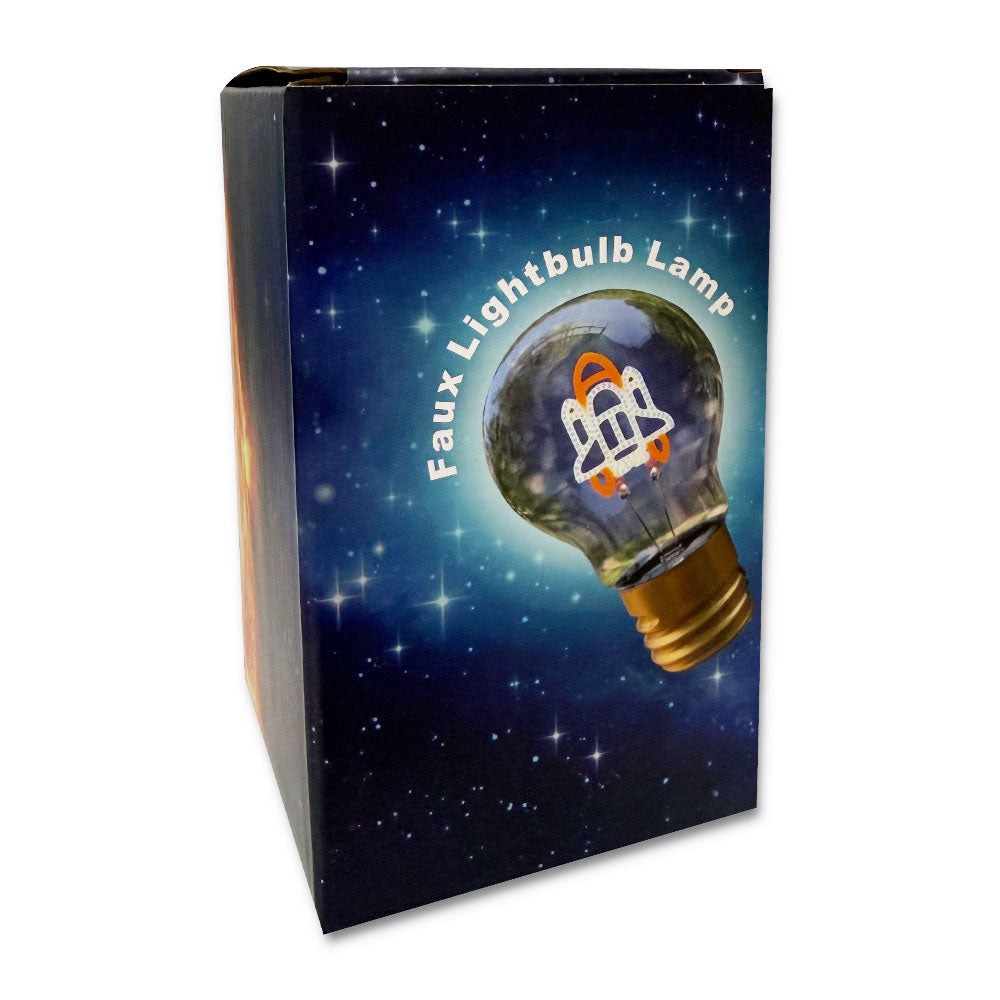 A product box with a starry space background features an illustration of the Spaceship LED Lightbulb showing a rocket ship inside, with "Faux Lightbulb Lamp" curving around the bulb—perfect for any kid's room.