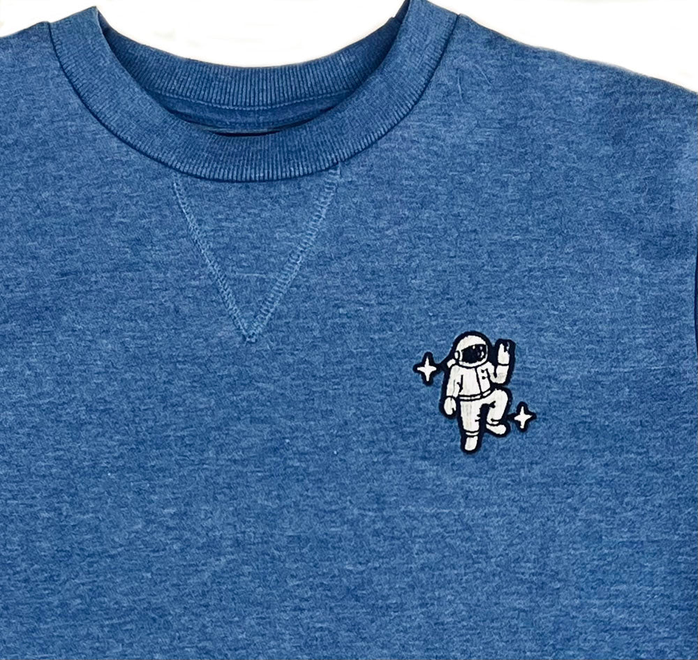 The Astronaut Embroidered Icon Crewneck Sweatshirt is a blue unisex crewneck featuring a small embroidered astronaut holding up a peace sign with star accents—ideal as a space-themed gift.
